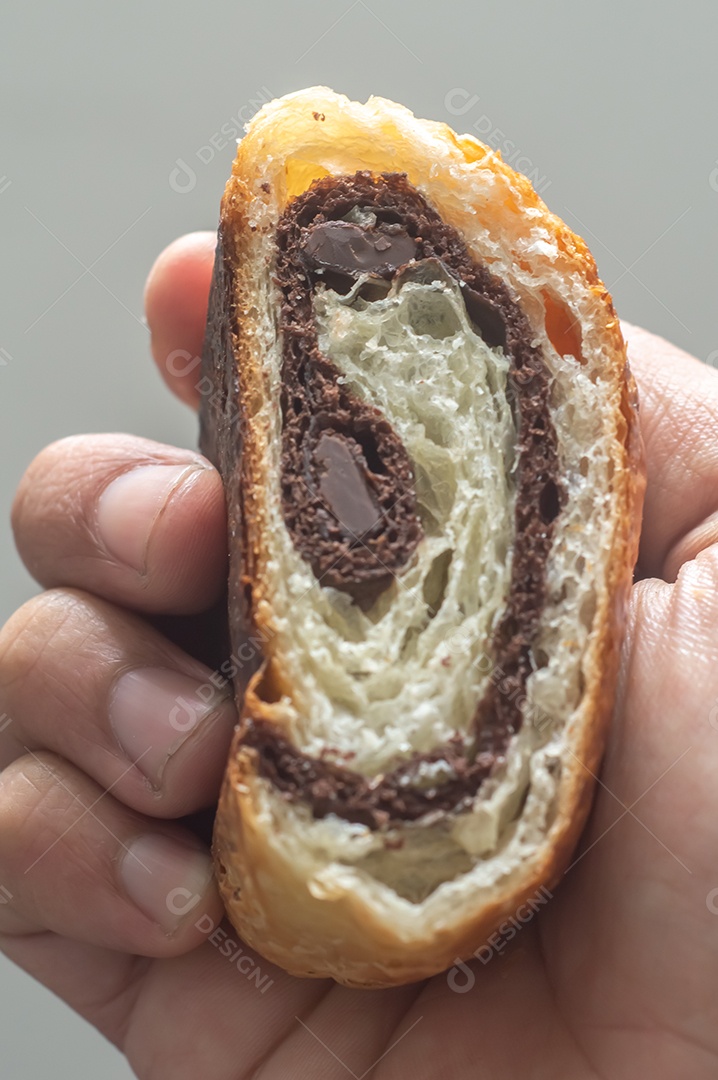 Mãos segurando pão chocolate, croissant de chocolate com fundo branco