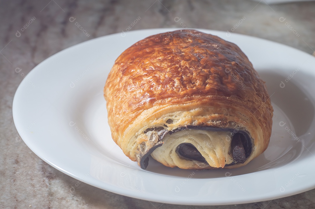 Pão chocolate, croissant de chocolate sobre prato branco