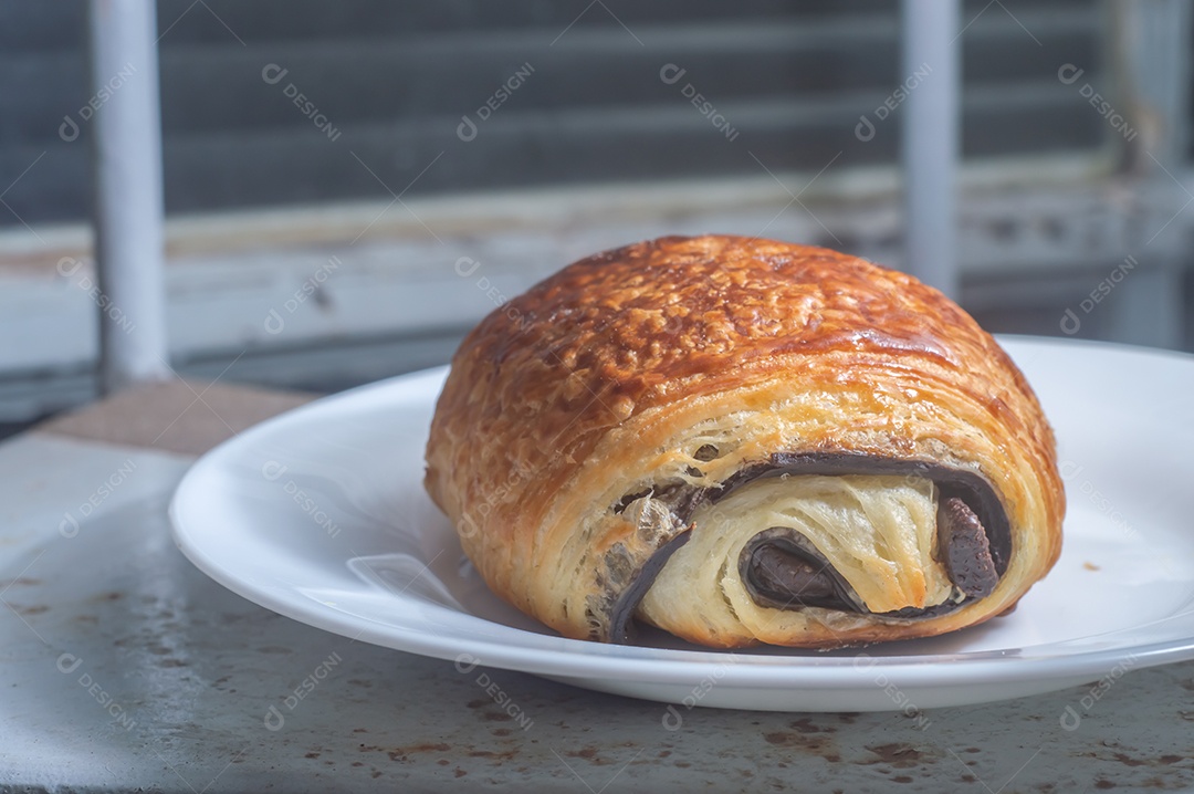 Pão chocolate, croissant de chocolate sobre prato branco