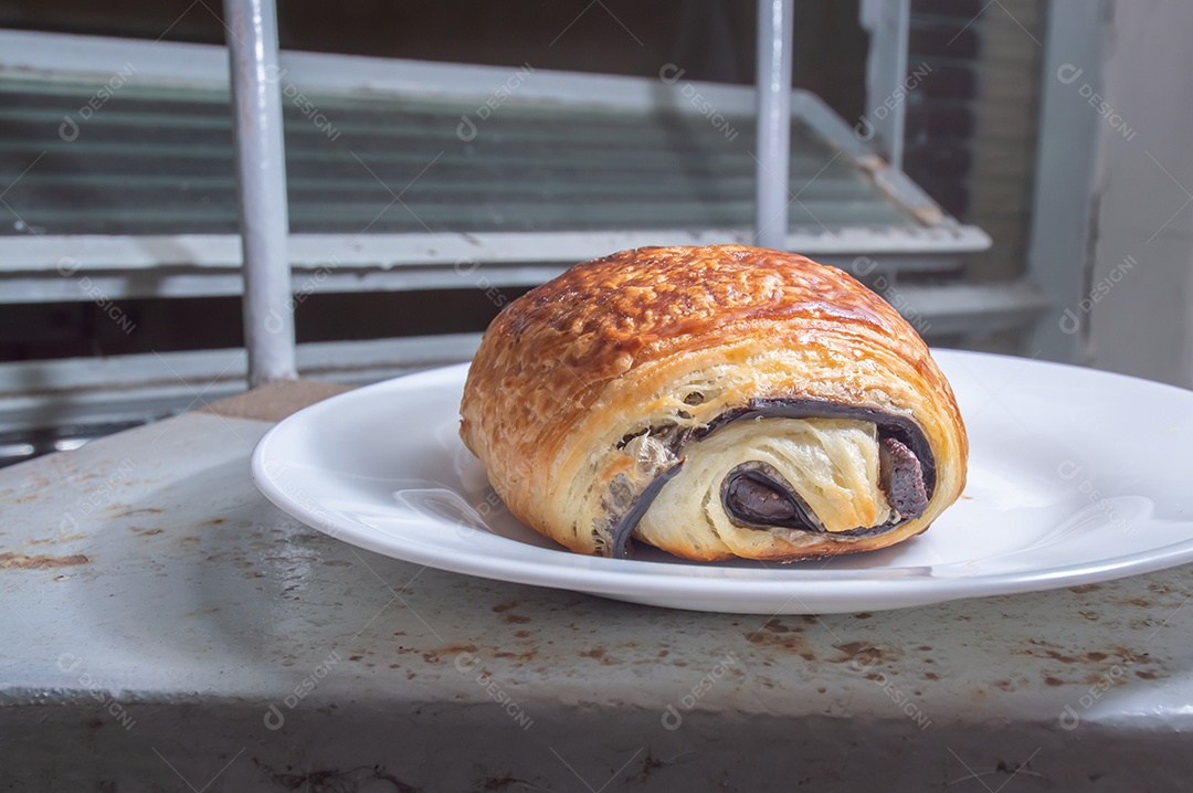 Pão chocolate, croissant de chocolate sobre prato branco