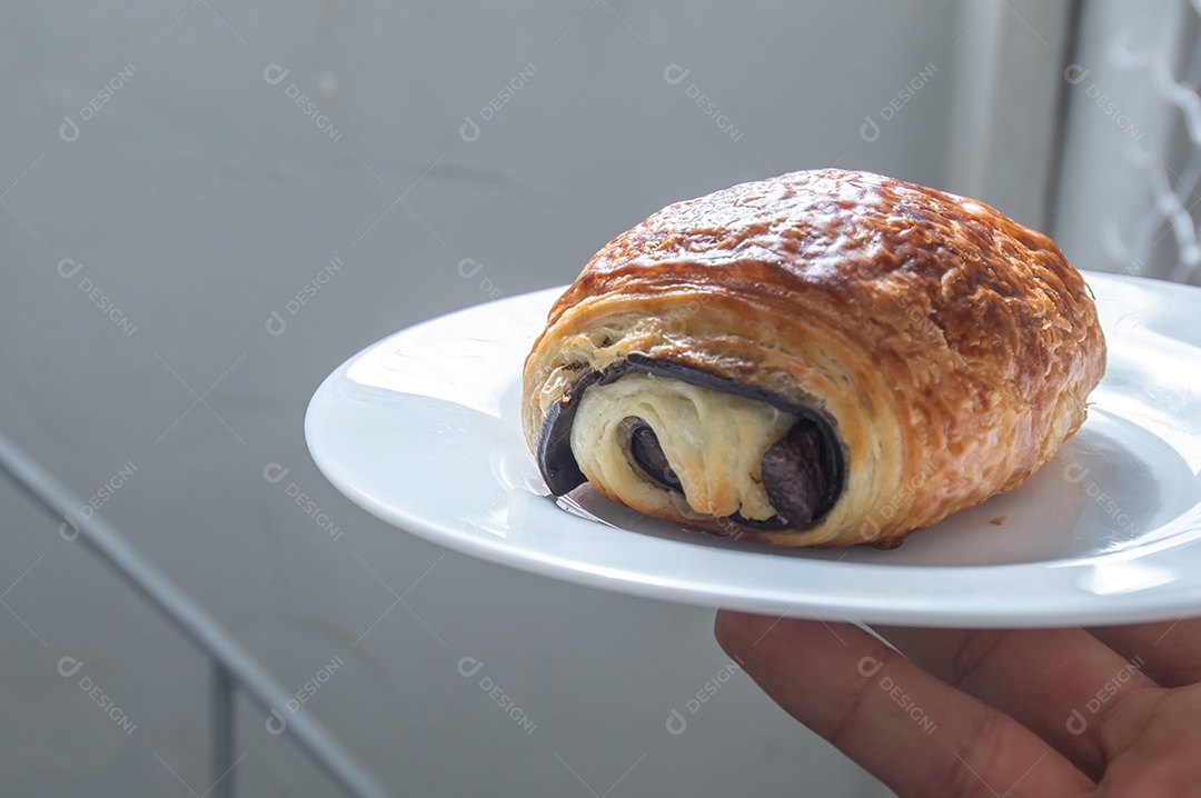 Pão chocolate, croissant de chocolate sobre prato branco