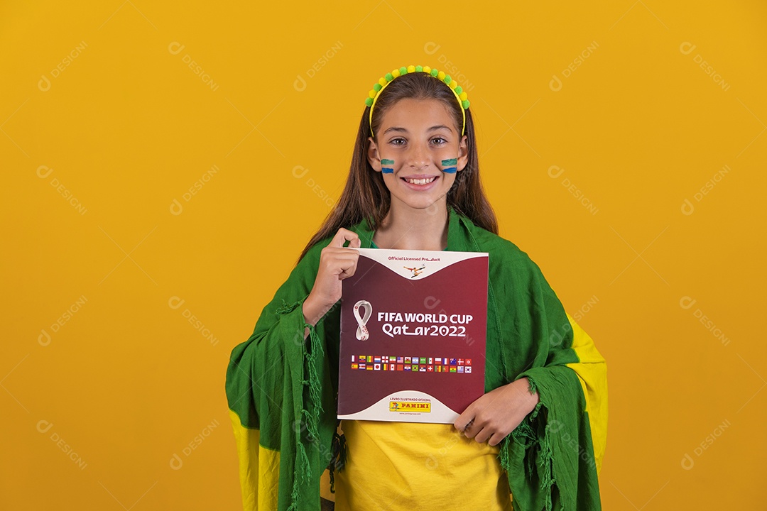 Linda mulher jovem brasileira segurando album da copa do mundo