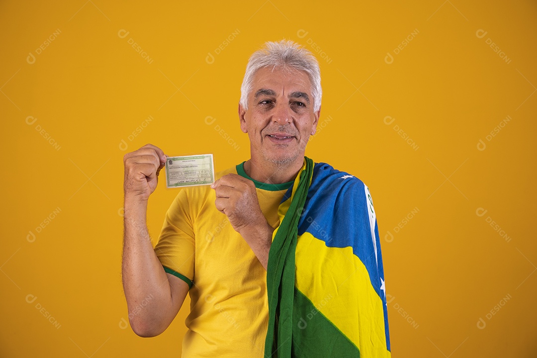 Homem idoso torcedor segurando documento usando camiseta da seleção brasileira