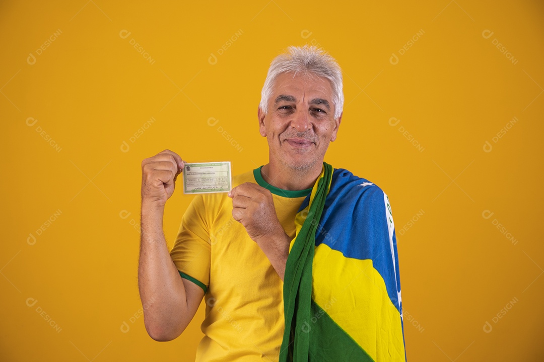 Homem idoso torcedor segurando documento usando camiseta da seleção brasileira