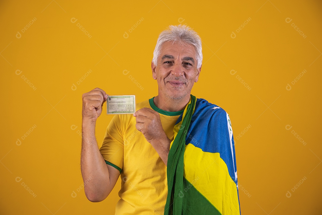 Homem idoso torcedor segurando documento usando camiseta da seleção brasileira