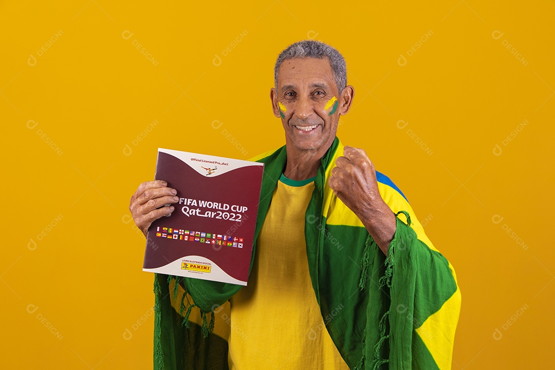 Homem idoso torcedor do brasileiro segurando álbum da copa do mundo