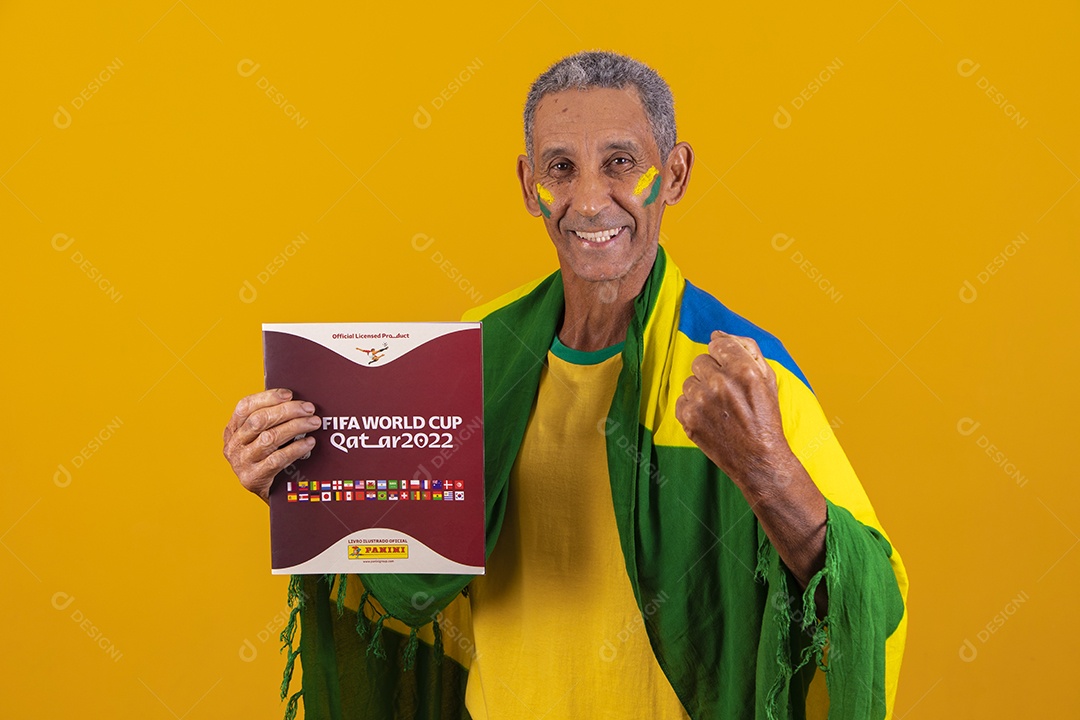 Homem idoso torcedor do brasileiro segurando álbum da copa do mundo