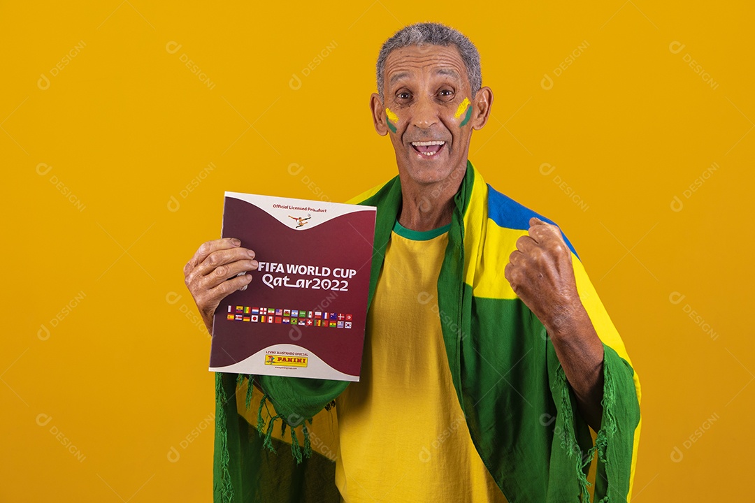 Homem idoso torcedor do brasileiro segurando álbum da copa do mundo