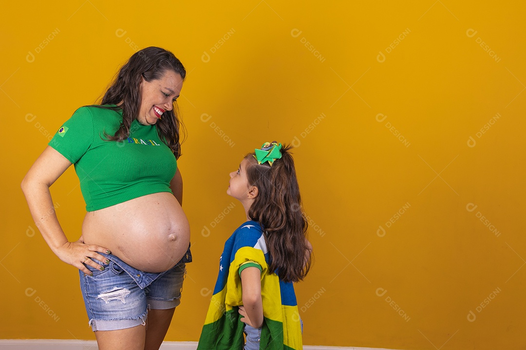 Mulher gravida ao lado de sua filha torcedoras do brasil