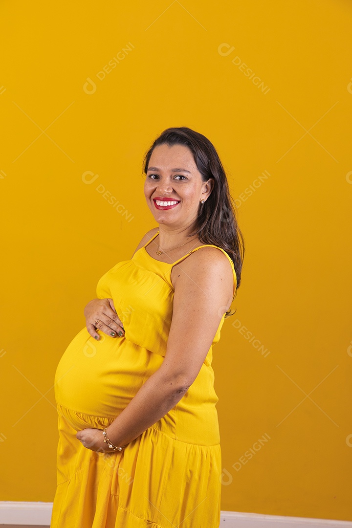 Mulher gestante usando vestido amarelo com temática copa do mundo