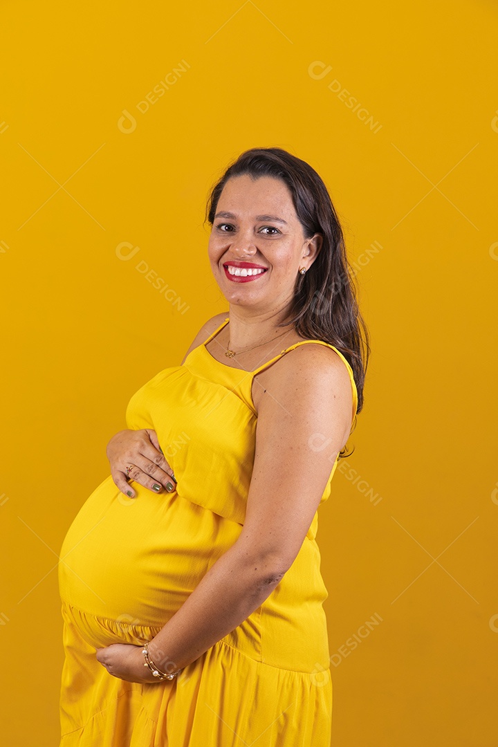 Mulher gestante usando vestido amarelo com temática copa do mundo