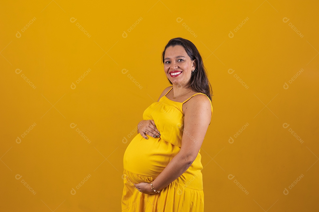 Mulher gestante usando vestido amarelo com temática copa do mundo