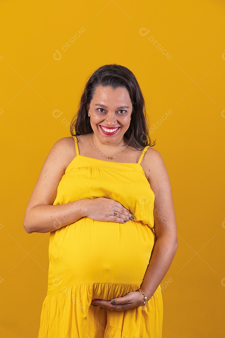 Mulher gestante usando vestido amarelo com temática copa do mundo