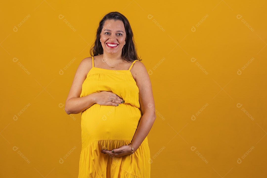 Mulher gestante usando vestido amarelo com temática copa do mundo