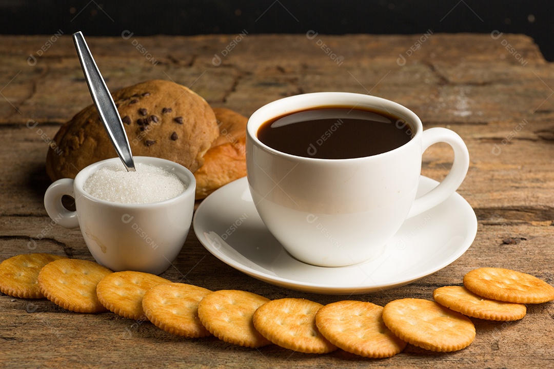 Xícara de café em uma tábua de madeira e biscoitos.