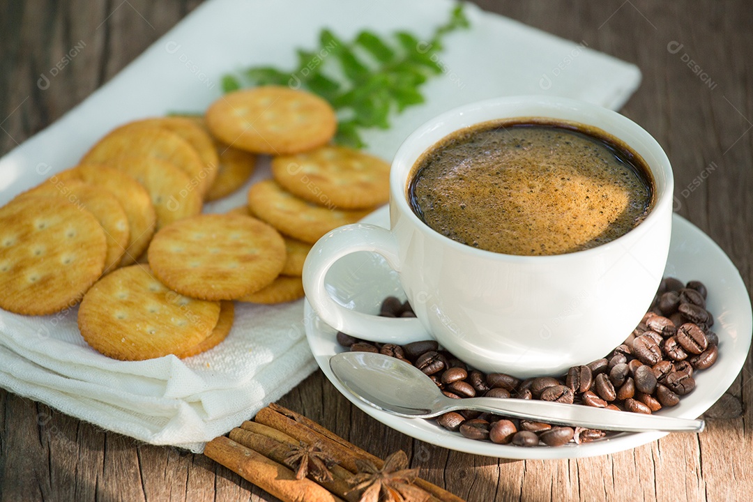 Xícara de café em uma tábua de madeira e biscoitos.