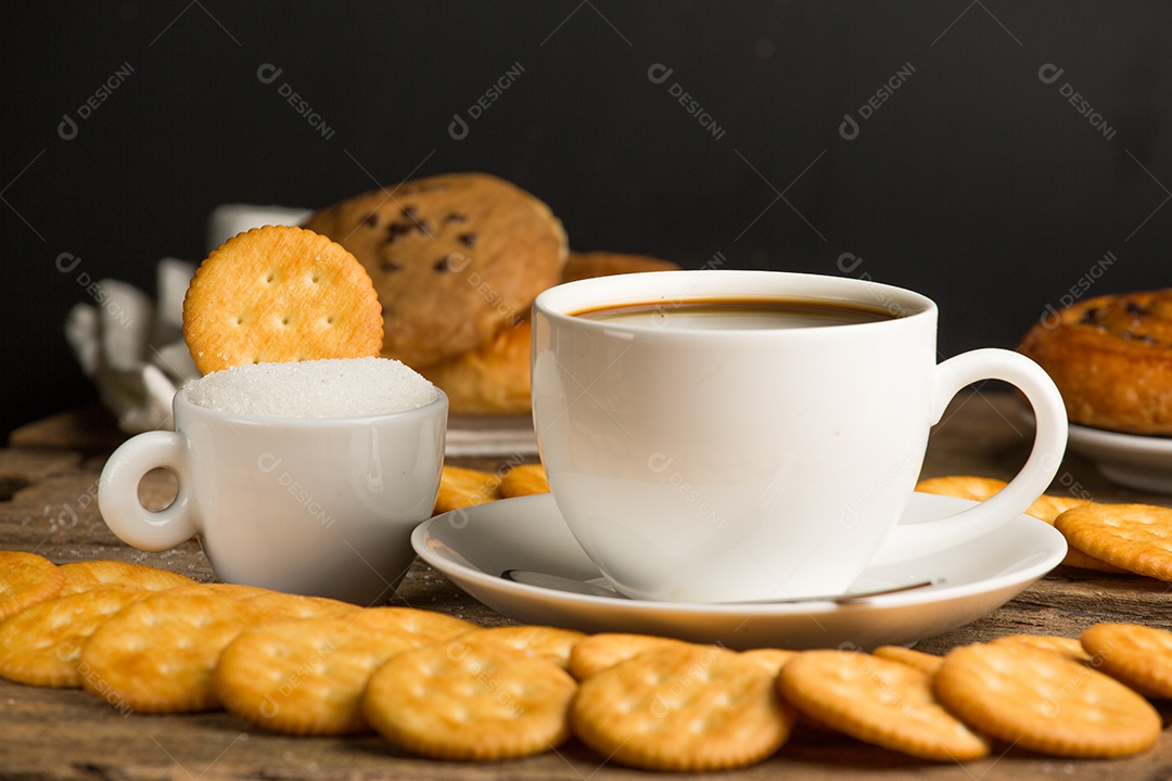 Xícara de café em uma tábua de madeira e biscoitos