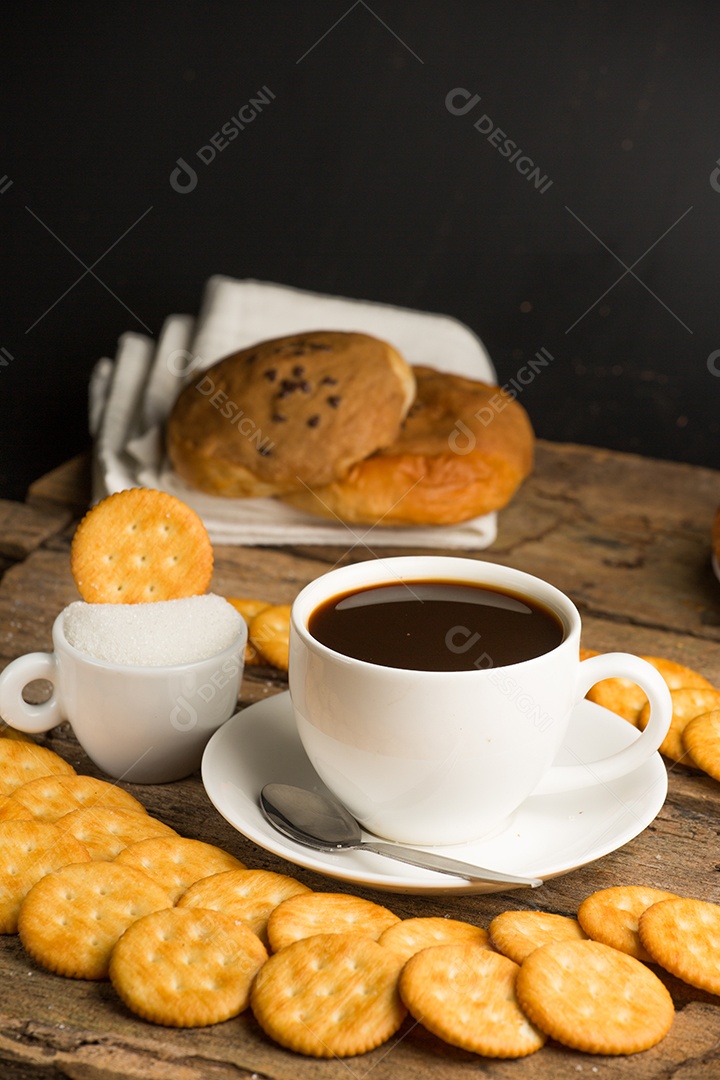 Xícara de café em uma tábua de madeira e biscoitos