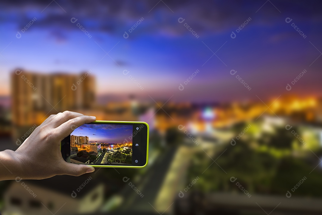 Mão feminina com smartphone tirando uma foto do fundo da construção