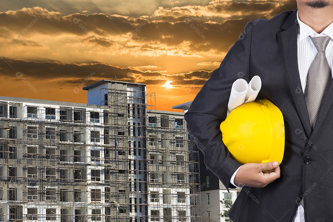 Engenheiro segurando o capacete para trabalhar na base do edifício.