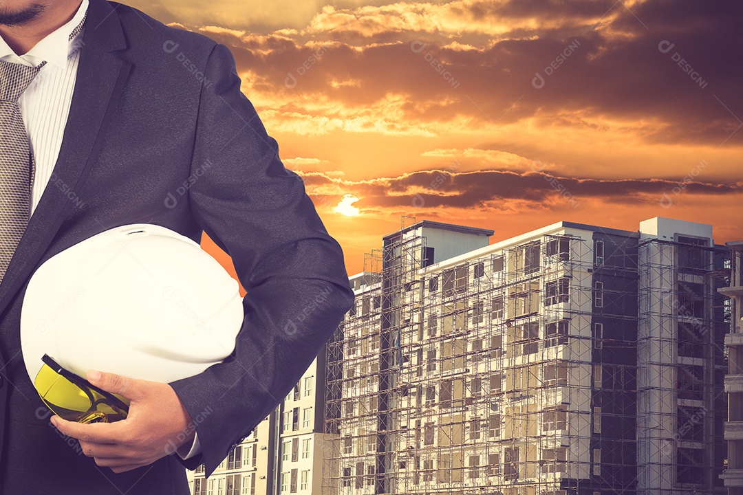 Engenheiro segurando o capacete para trabalhar na base do edifício construção.
