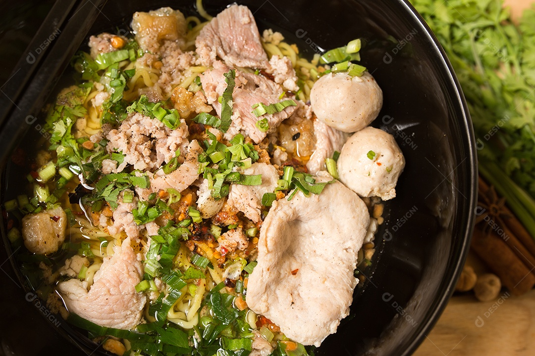 Tigela de macarrão com legumes e ovo cozido na ta de madeira.