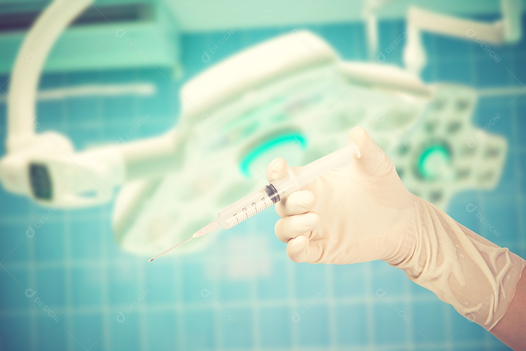 Segurando a seringa na cor vintage do fundo da sala cirúrgica.