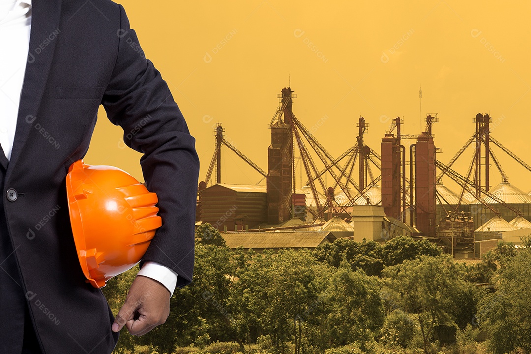 Engenheiro segurando capacete laranja para segurança dos trabalhadores.