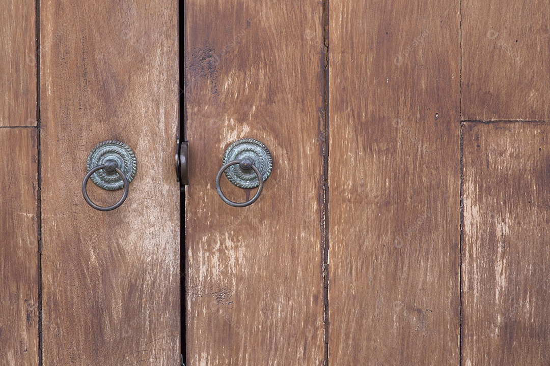 Parte da porta de madeira com alça de metal.