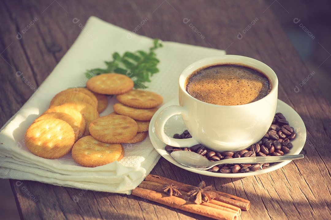 Xícara de café em uma tábua de madeira e cor vintage de biscoitos.