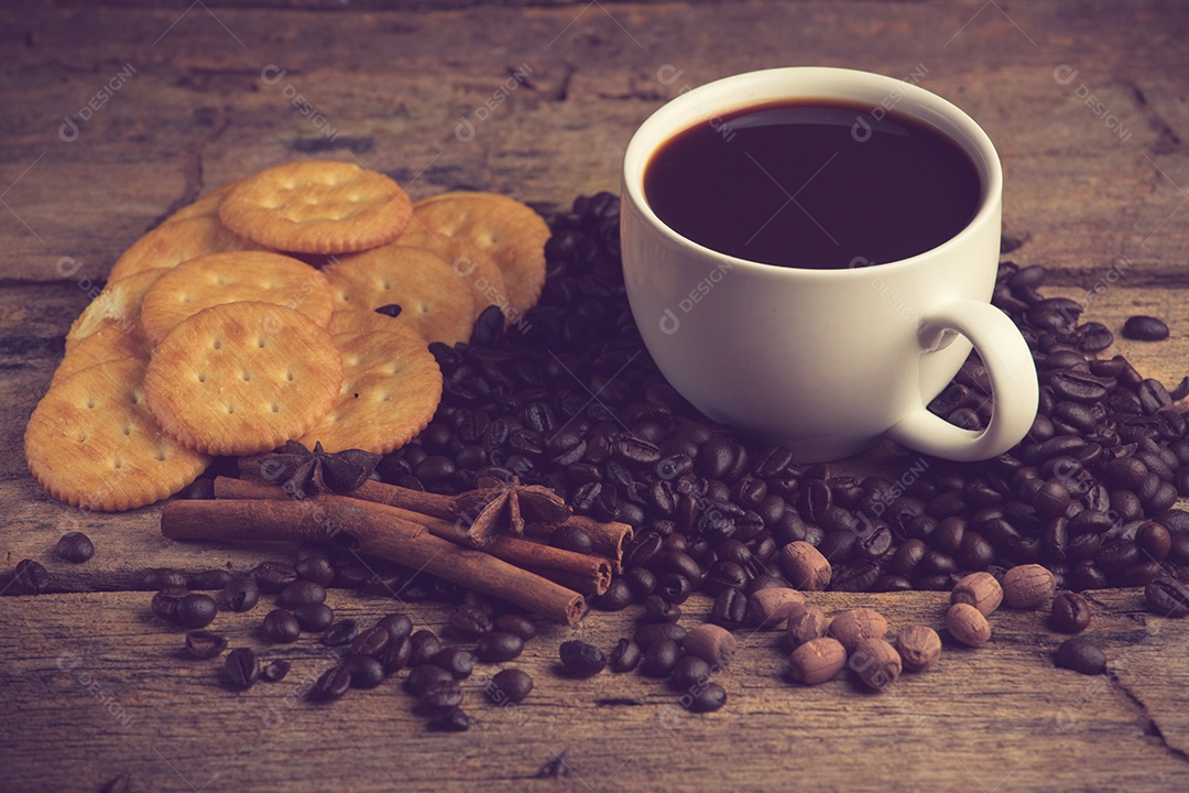 Xícara de café em uma tábua de madeira e biscoitos.