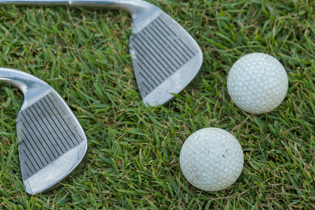 Clube de golfe e bola na grama.