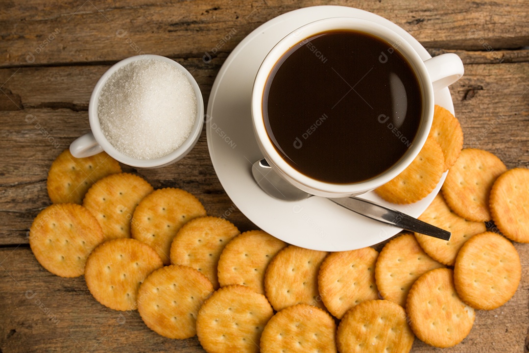 Xícara de café em uma tábua de madeira e biscoitos.