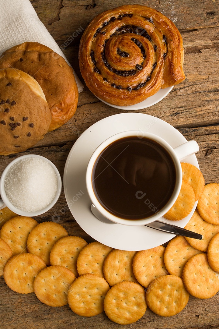 Xícara de café em uma tábua de madeira e biscoitos.