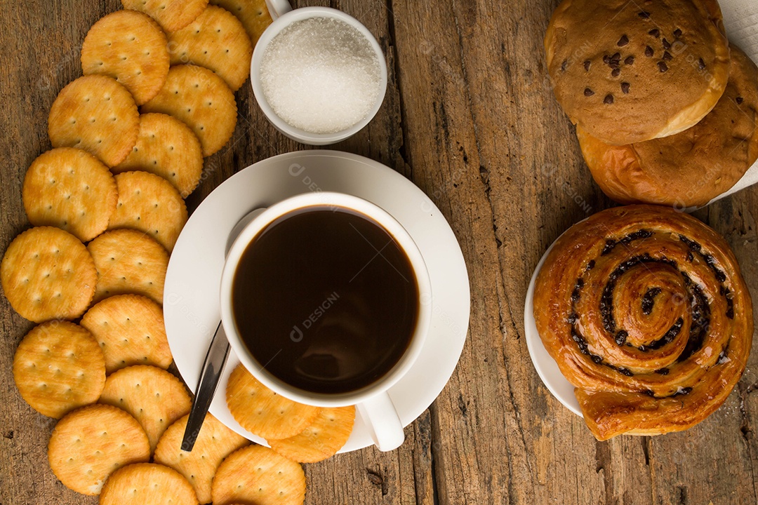 Xícara de café em uma tábua de madeira e biscoitos.