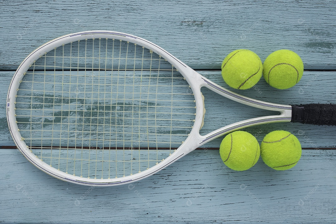 Vista da raquete de tênis e bolas na mesa de madeira