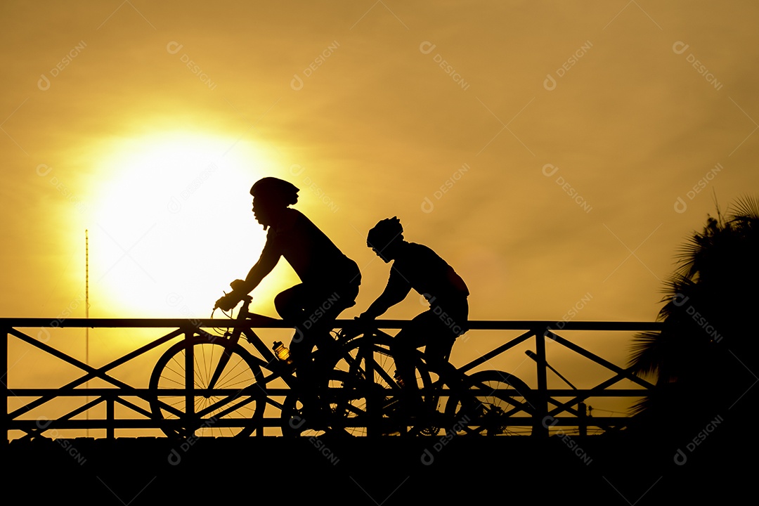 Silhueta de motociclista na ponte e pôr do sol