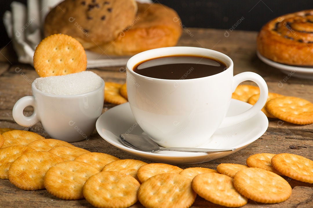 Xícara de café em uma placa de madeira e biscoitos