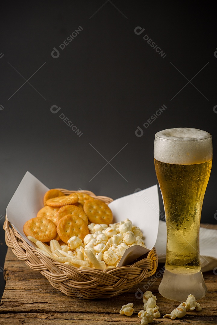 Copo de cerveja e pipoca em um fundo de madeira