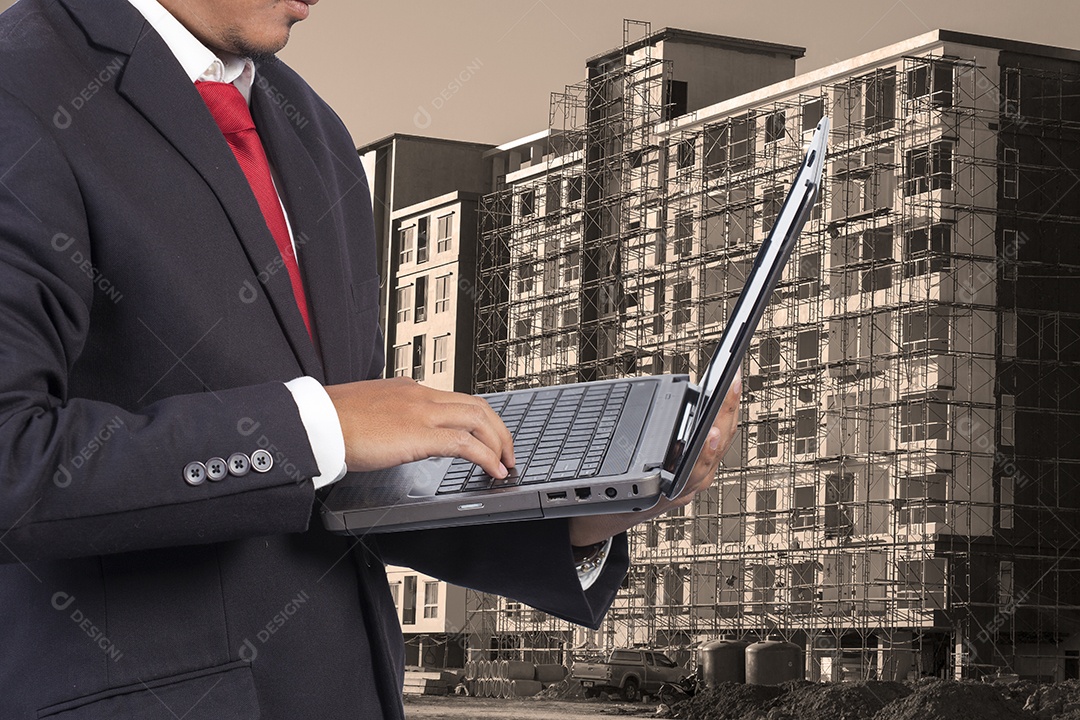 Engenheiro segurando laptop para segurança de trabalhadores em fundo de construção