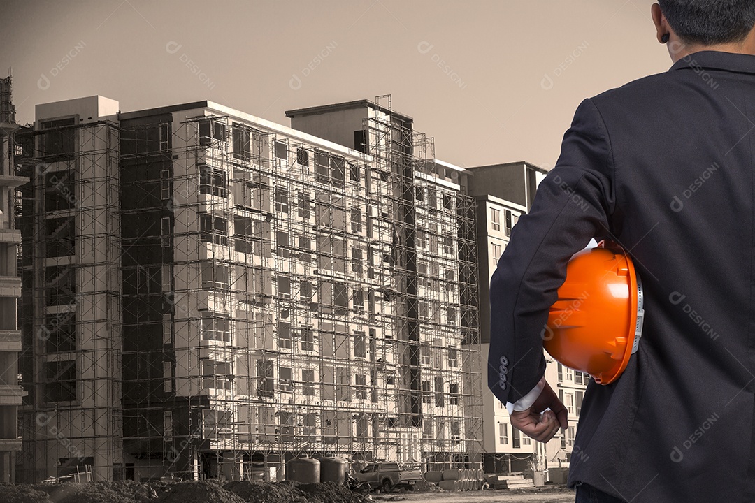 Engenheiro segurando capacete laranja para segurança dos trabalhadores