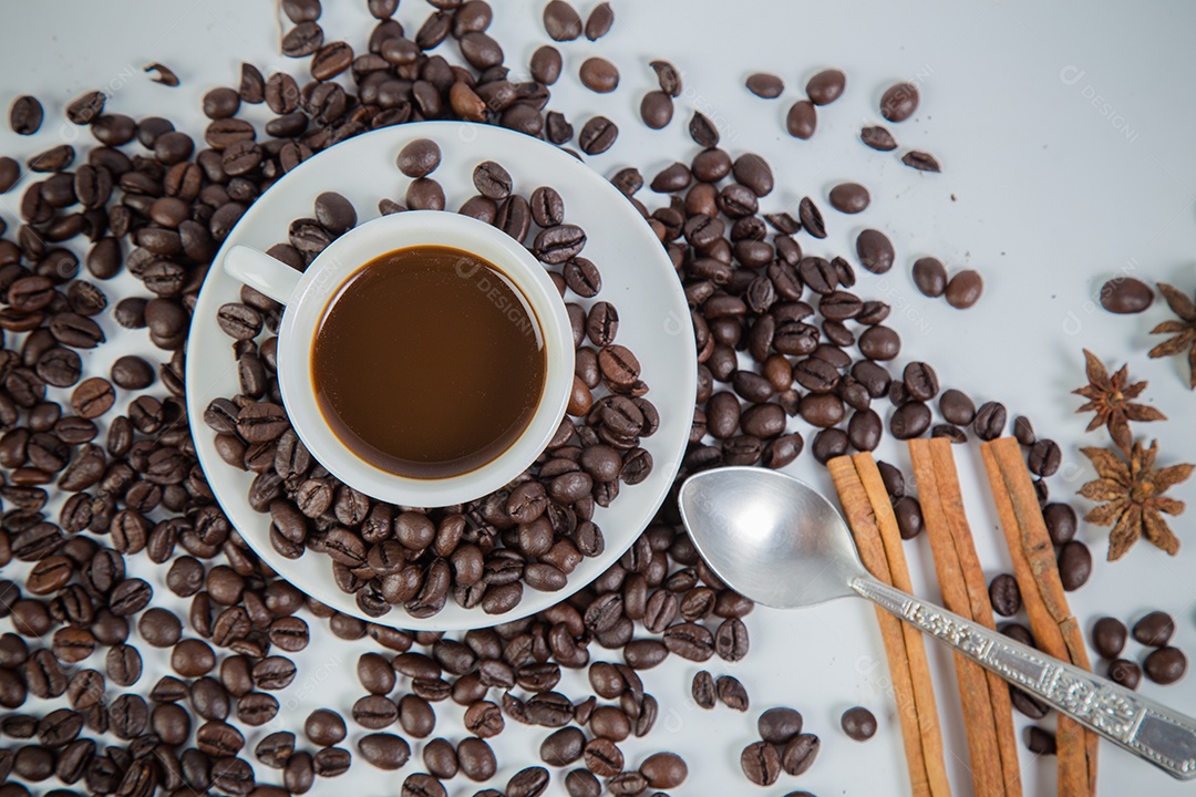 Xícara de café e feijão em um fundo branco.