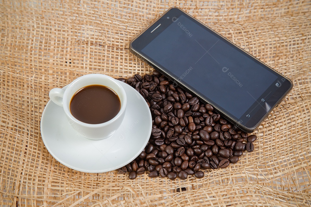 Xícara de café e feijão em um fundo branco.