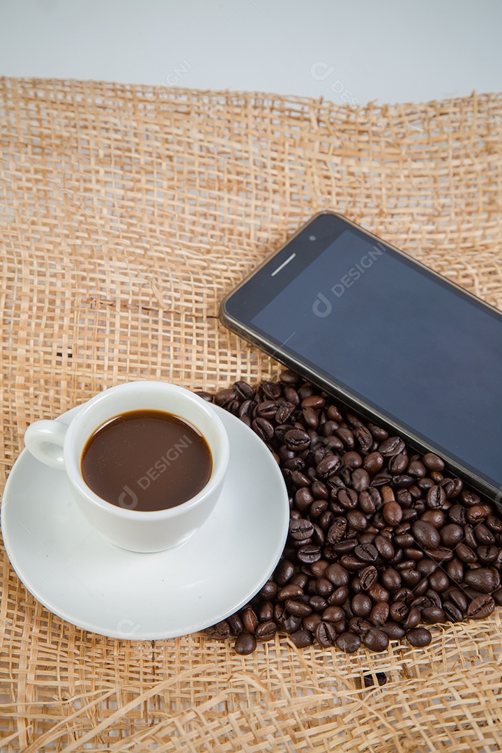 Xícara de café e feijão em um fundo branco.