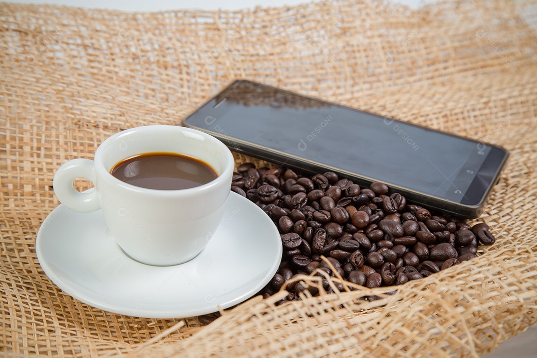 Xícara de café e feijão em um fundo branco.