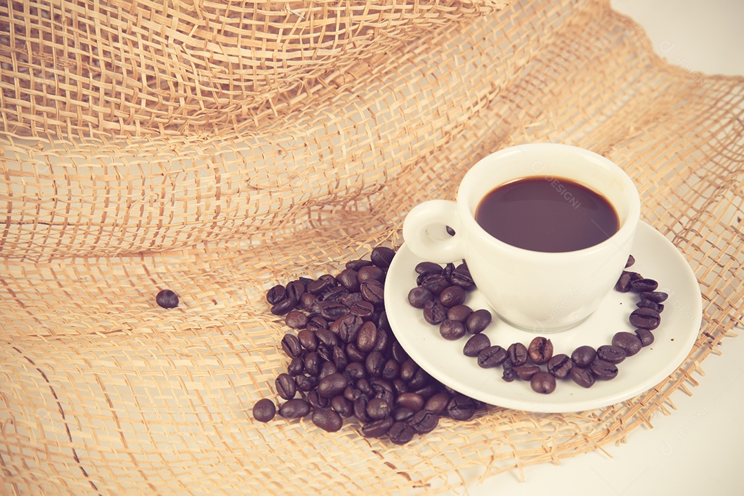 Xícara de café e feijão em uma cor vintage de fundo branco.