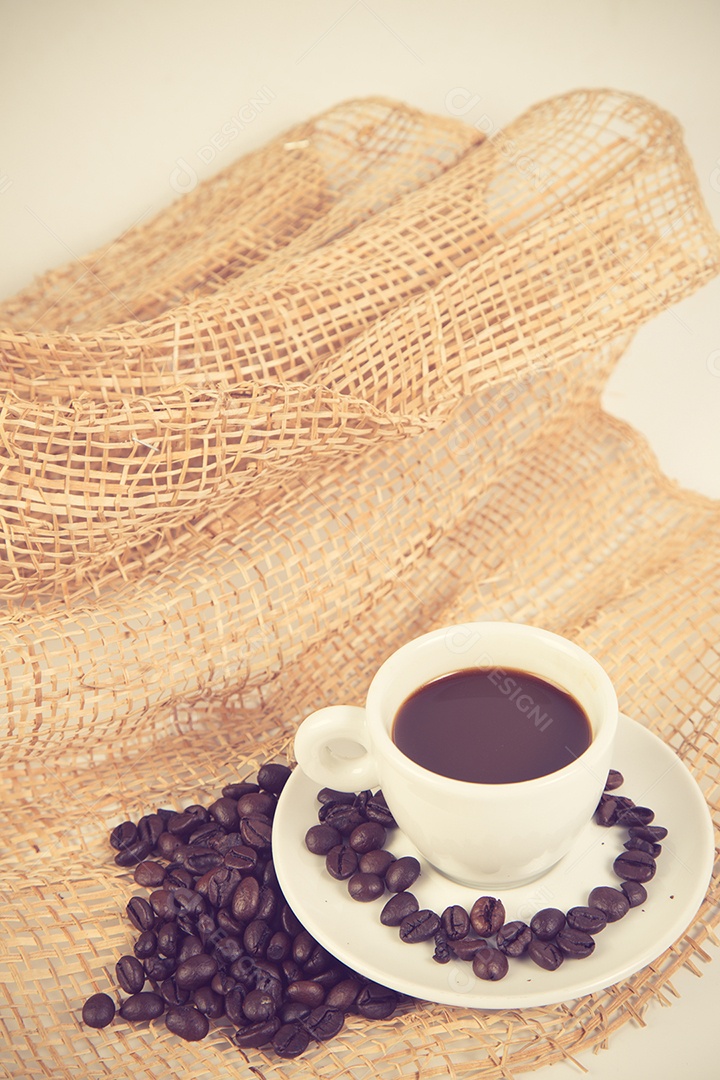 Xícara de café e feijão em uma cor vintage de fundo branco.