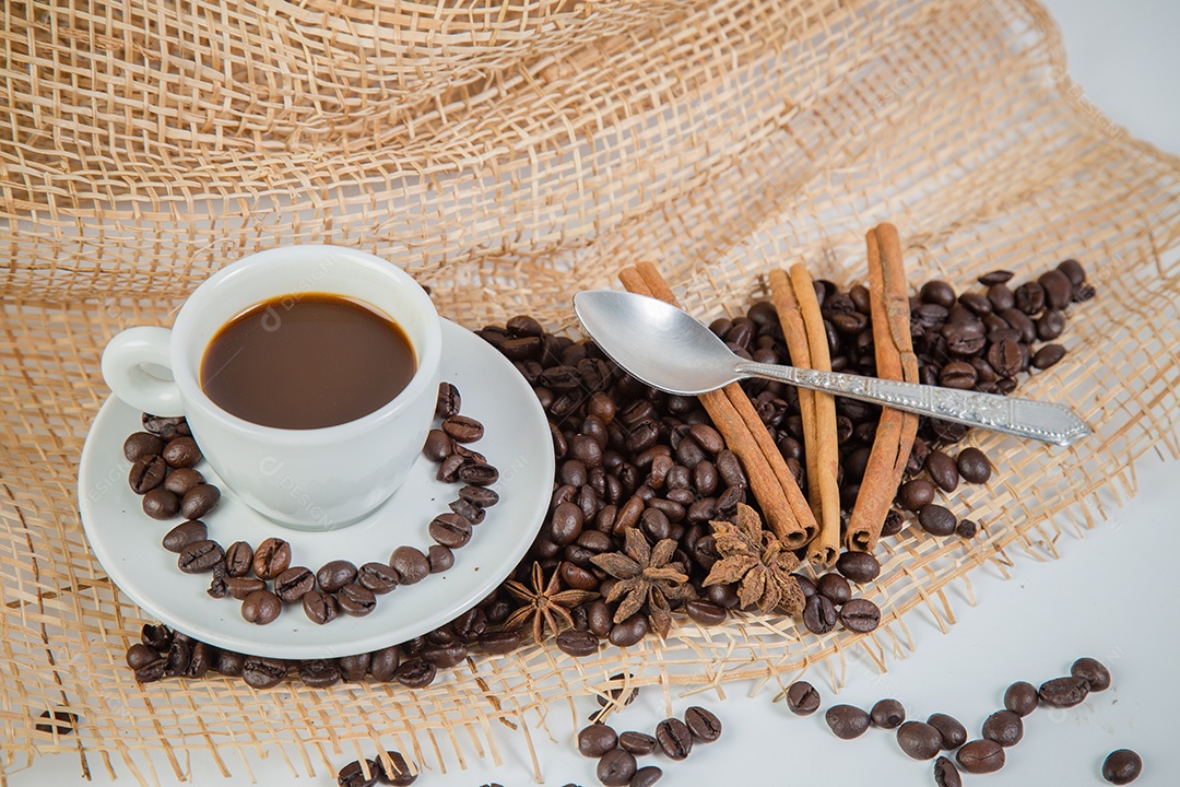Xícara de café e grãos em um fundo branco.