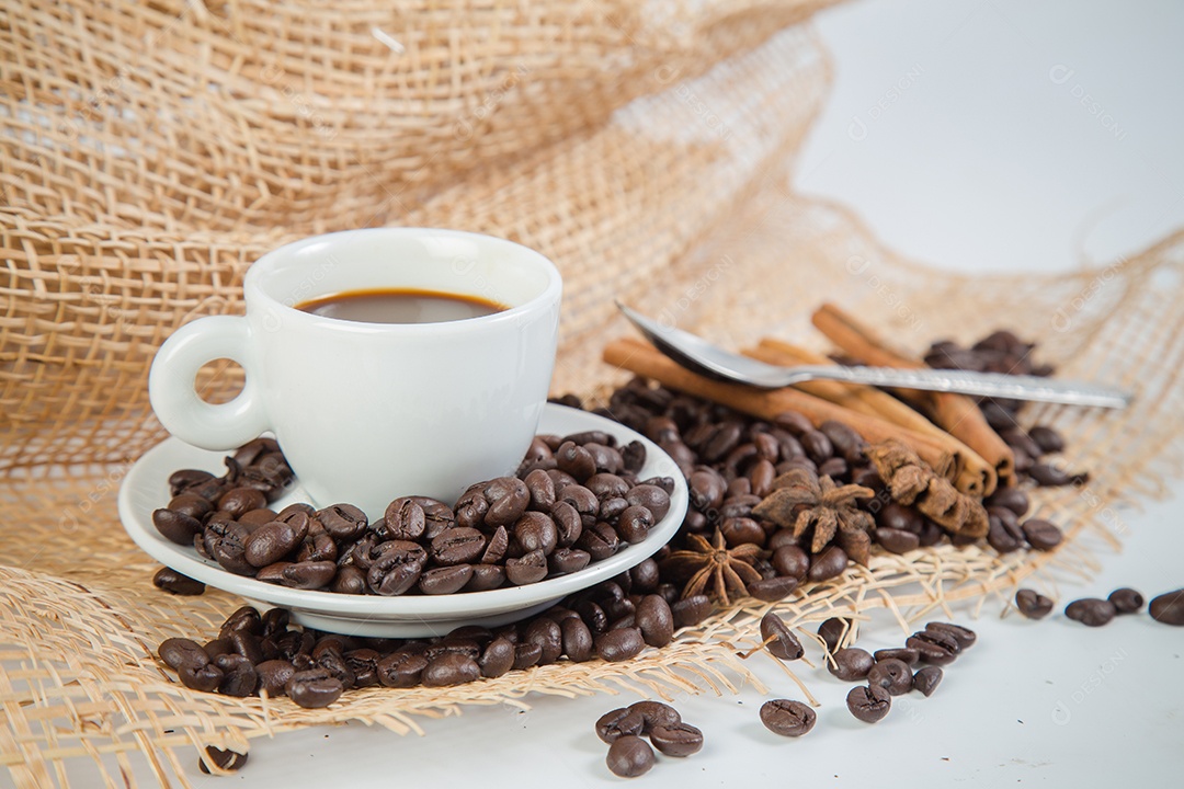Xícara de café e feijão em um fundo branco.