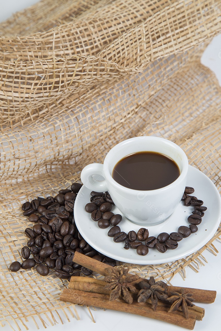 Xícara de café e feijão em um fundo branco.